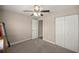 Neutral bedroom with carpet, a ceiling fan, double closets, and a door leading to another room at 4730 Sw 138Th Ln, Ocala, FL 34473