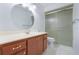 Bathroom with vanity and sink, round mirror, and a tiled shower with a sliding door at 5202 Greenway Drive, Orlando, FL 32819