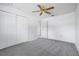 Bedroom with a ceiling fan, neutral carpeting, and a closet with sliding doors at 5202 Greenway Drive, Orlando, FL 32819