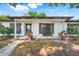 Charming home with a cozy front porch, complete with decorative plants and a quaint bench at 5202 Greenway Drive, Orlando, FL 32819