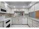 This well-lit kitchen features stylish white cabinetry, a white backsplash and modern appliances at 5202 Greenway Drive, Orlando, FL 32819