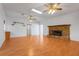 Spacious living room has hardwood floors, fan, brick fireplace and ample natural light at 5202 Greenway Drive, Orlando, FL 32819