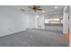 Carpeted living space featuring neutral walls, ceiling fan, view to kitchen and pass-through to adjacent room at 5202 Greenway Drive, Orlando, FL 32819