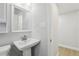 Bright bathroom featuring a white pedestal sink, mirror, and modern fixtures at 5215 Ashwood Pl, Orlando, FL 32808
