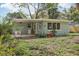 Single-story home featuring light blue paint, a covered patio, and a well maintained, landscaped yard at 5215 Ashwood Pl, Orlando, FL 32808