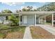 Inviting front entrance with covered carport, and well-manicured lawn at 5215 Ashwood Pl, Orlando, FL 32808