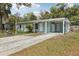 Exterior of a light blue house with a spacious driveway and covered carport at 5215 Ashwood Pl, Orlando, FL 32808