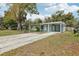 Spacious front yard with a carport featuring a light blue exterior at 5215 Ashwood Pl, Orlando, FL 32808