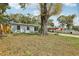Exterior shot of a light blue home featuring a large tree and spacious yard at 5215 Ashwood Pl, Orlando, FL 32808