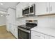 Modern kitchen with white cabinets, stainless steel appliances, and sleek countertops at 5215 Ashwood Pl, Orlando, FL 32808