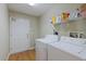 Functional laundry room includes washer, dryer, shelving and a door, providing convenience and ample storage space at 5347 Pecan Rd, Ocala, FL 34472