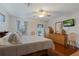 Main bedroom with wood floors, ceiling fan, dresser, mirror, and mounted television at 5347 Pecan Rd, Ocala, FL 34472