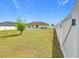 Spacious backyard with a white vinyl fence, green lawn, a small patio and a stone bird bath at 5361 Se 92Nd St, Ocala, FL 34480