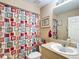 Clean bathroom featuring a toilet, sink, mirror, and shower with bright colorful curtain at 5361 Se 92Nd St, Ocala, FL 34480