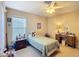 Well-lit bedroom with a ceiling fan, a window with blinds, and matching nightstand and desk at 5361 Se 92Nd St, Ocala, FL 34480