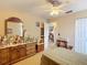 Cozy bedroom featuring a ceiling fan and a dresser with many small religious statues and pictures at 5361 Se 92Nd St, Ocala, FL 34480
