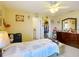 Bedroom showcasing a ceiling fan, access to bathroom and closet, and personal decorations at 5361 Se 92Nd St, Ocala, FL 34480