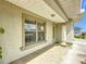 Covered front porch featuring tiled flooring, decorative columns, and a view of the front lawn at 5361 Se 92Nd St, Ocala, FL 34480