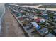 Stunning aerial view of oceanfront homes along the coast, showcasing beach access and vibrant neighborhood setting at 6480 S Atlantic Ave, New Smyrna Beach, FL 32169