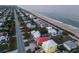 Aerial photograph of homes by beach; neighborhood view showcasing proximity to the sandy shore and ocean at 6480 S Atlantic Ave, New Smyrna Beach, FL 32169