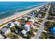 Aerial view of beach homes, showcasing oceanfront property with vibrant blue water and clear sky at 6480 S Atlantic Ave, New Smyrna Beach, FL 32169