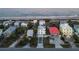 Drone image of beachfront real estate, close to the ocean featuring a red roof and modern builds at 6480 S Atlantic Ave, New Smyrna Beach, FL 32169