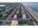 High angle drone shot of beach homes. Prime beachfront properties adjacent to the shoreline, palm trees nearby at 6480 S Atlantic Ave, New Smyrna Beach, FL 32169
