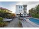 Backyard featuring a pool, lounge area, and tropical landscaping for outdoor relaxation and entertainment at 6480 S Atlantic Ave, New Smyrna Beach, FL 32169