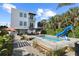 Backyard featuring a pool, lounge area, and tropical landscaping for outdoor relaxation and entertainment at 6480 S Atlantic Ave, New Smyrna Beach, FL 32169