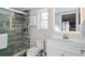 Modern bathroom featuring a glass shower with wood-look tiling, a vanity with sink, and ample lighting at 6480 S Atlantic Ave, New Smyrna Beach, FL 32169