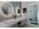 Contemporary bathroom featuring dual vessel sinks, LED mirrors, and a glass-enclosed shower at 6480 S Atlantic Ave, New Smyrna Beach, FL 32169