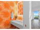 Unique powder room with vibrant tropical wallpaper, modern sink, and elegant fixtures at 6480 S Atlantic Ave, New Smyrna Beach, FL 32169