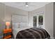 Cozy bedroom featuring a comfortable bed with decorative headboard, and a view of outdoor plants through a large window at 6480 S Atlantic Ave, New Smyrna Beach, FL 32169