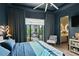 Cozy bedroom with a view to an outdoor balcony with plenty of nature and a modern chair at 6480 S Atlantic Ave, New Smyrna Beach, FL 32169