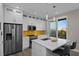 Modern kitchen with stainless steel appliances, island with seating and bright yellow backsplash at 6480 S Atlantic Ave, New Smyrna Beach, FL 32169