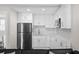 Bright kitchen featuring white cabinetry, stainless steel refrigerator, modern backsplash, and ample counter space at 6480 S Atlantic Ave, New Smyrna Beach, FL 32169