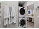Efficient laundry area with stacked washer and dryer, adjacent to a beautifully designed bathroom at 6480 S Atlantic Ave, New Smyrna Beach, FL 32169