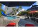 Backyard pool featuring a slide, lounge area, and tropical landscaping, perfect for outdoor entertainment at 6480 S Atlantic Ave, New Smyrna Beach, FL 32169