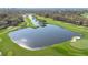 Picturesque aerial view of a pristine golf course with a serene lake and manicured greens at 6735 Edgeworth Dr, Orlando, FL 32819