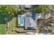 Birds eye view of backyard pool, patio, mature trees, and neutral roof with green grass and landscaping at 6735 Edgeworth Dr, Orlando, FL 32819