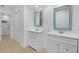 Bright bathroom featuring dual vanities with framed mirrors and a doorway to the toilet and shower room at 6735 Edgeworth Dr, Orlando, FL 32819