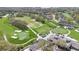 Scenic aerial view of a golf course highlighting the putting green, golf carts, and clubhouse at 6735 Edgeworth Dr, Orlando, FL 32819