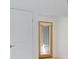 Hallway featuring a white interior door with silver handle and a wooden door with a glass insert and blind at 6735 Edgeworth Dr, Orlando, FL 32819