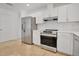 Clean kitchen featuring white cabinets, stainless steel appliances, and a light wood countertop at 6735 Edgeworth Dr, Orlando, FL 32819