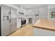 Modern kitchen with stainless steel appliances, granite countertops, white subway tile backsplash and wood-style tile floors at 6735 Edgeworth Dr, Orlando, FL 32819