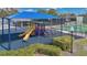 Community playground with a large blue sunshade, slides, and basketball court at 6735 Edgeworth Dr, Orlando, FL 32819