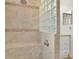 Shower featuring stone-like tiling, glass-block divider and shower head at 6735 Edgeworth Dr, Orlando, FL 32819