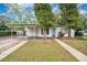Charming single-story home featuring a covered carport, blue front door, and well-maintained front yard at 7121 Stockholm Way, Orlando, FL 32822