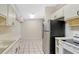 The kitchen features neutral cabinets, white appliances and tile floors at 7121 Stockholm Way, Orlando, FL 32822