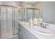 Clean bathroom featuring a double sink vanity, quartz countertops, and a glass-enclosed shower at 7359 Capstone Dr, Groveland, FL 34736